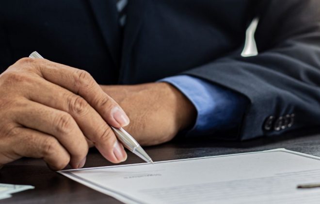 man signing document